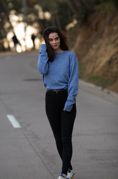 Wearing a blue sweater and black lady \ straight cut jeans
